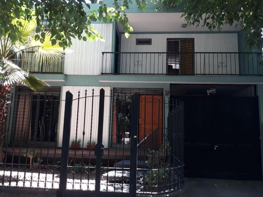 una casa con una valla negra y puertas naranjas en Quinta House en Mendoza