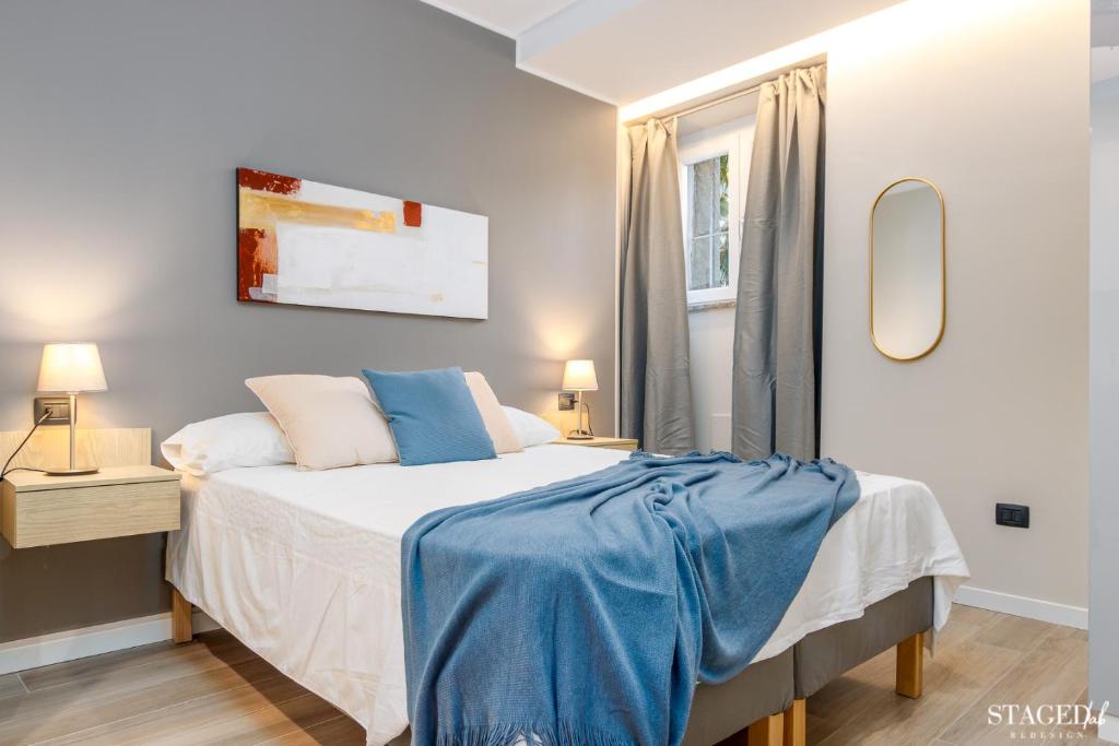 um quarto com uma cama com um cobertor azul em FEEL - Grand Alta Apartment em Bérgamo