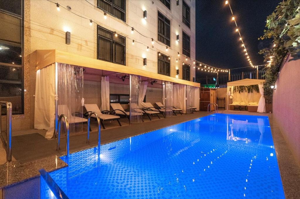 - une piscine en face d'un bâtiment la nuit dans l'établissement Daegu February Hotel Dongseongro, à Daegu