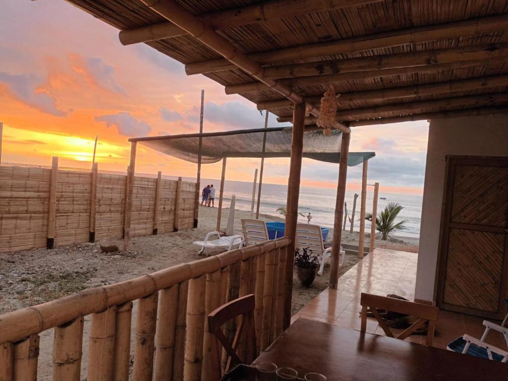 een huis op het strand met een zonsondergang bij Bungalows Sol y Mar in Canoas De Punta Sal