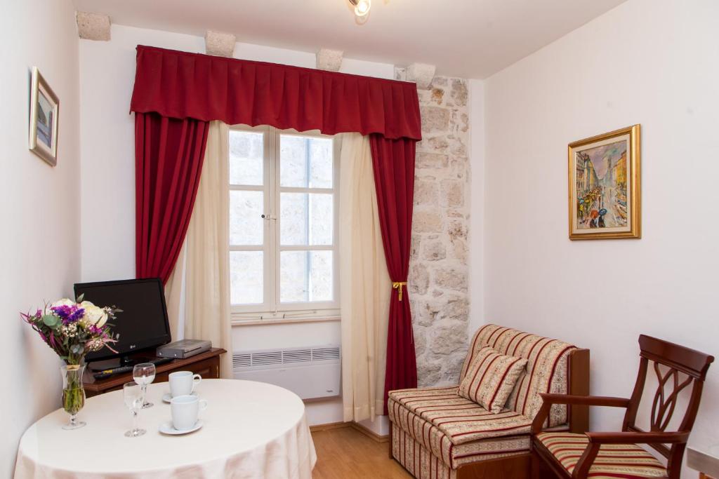 sala de estar con mesa y ventana en Apartments Lepur, en Dubrovnik
