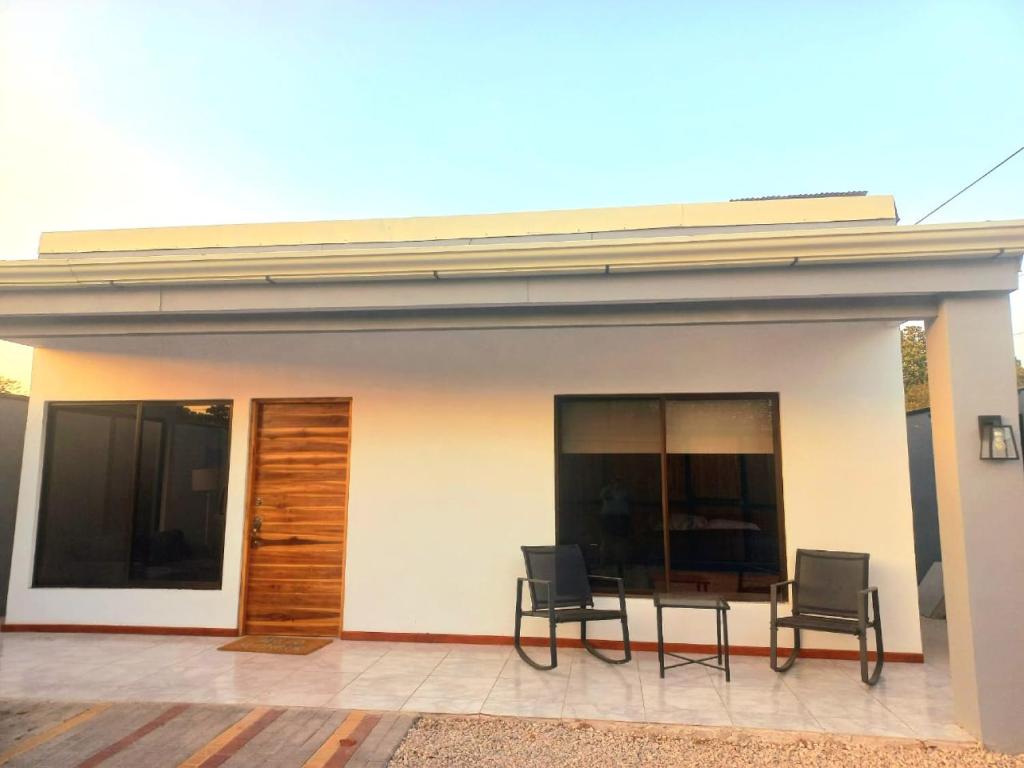 une maison avec 2 chaises et une table sur une terrasse dans l'établissement Casa con piscina, à Portegolpe