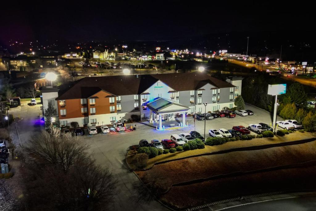 un edificio con coches estacionados en un estacionamiento por la noche en Holiday Inn Express Hotel & Suites Knoxville-North-I-75 Exit 112, an IHG Hotel, en Knoxville