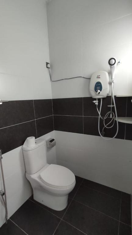 bagno con servizi igienici e telefono appeso al muro di Gopeng Serumah Holiday House a Gopeng