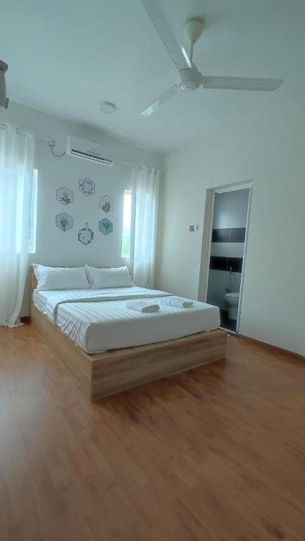 una camera da letto con un letto grande con pavimento in legno di Gopeng Serumah Holiday House a Gopeng