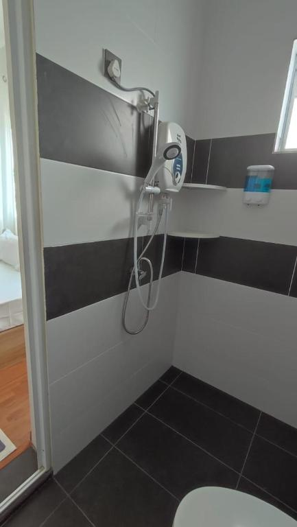 una doccia in bagno con parete in bianco e nero di Gopeng Serumah Holiday House a Gopeng