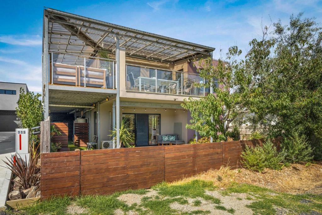 a house with a wooden fence in front of it at Back Beach Beauty in Smiths Beach
