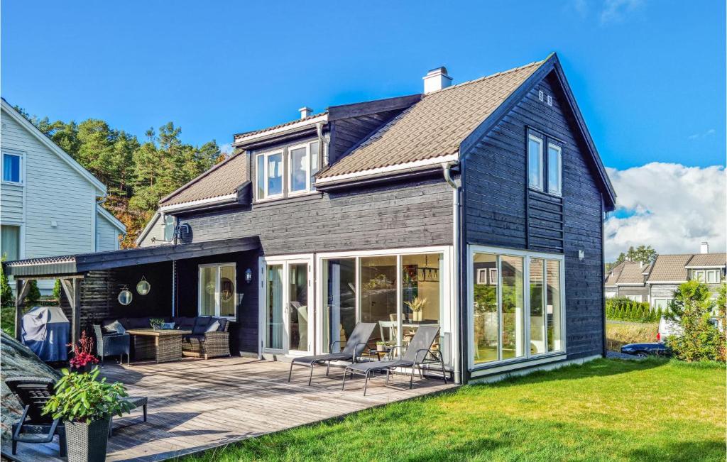 ein schwarzes Haus mit einer Terrasse in der Unterkunft Amazing Home In Risr With Wifi in Risør