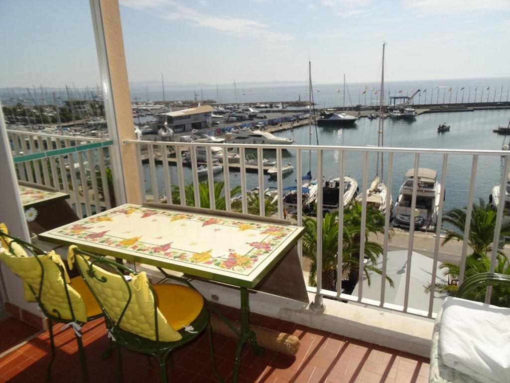 d'un balcon avec une table et des chaises ainsi qu'un port de plaisance. dans l'établissement Studio à Hyères Port avec loggia et parking - FR-1-335-187, à Hyères