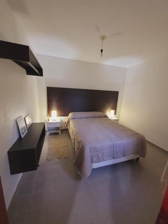 1 dormitorio con 1 cama grande, 2 mesas y 2 lámparas en Los Malvones en Viedma
