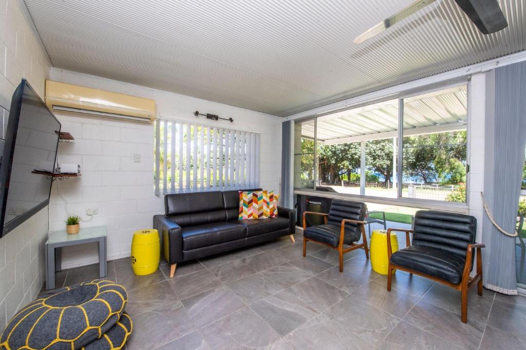 a living room with a black leather couch and chairs at Island View Apt 1 in Arcadia