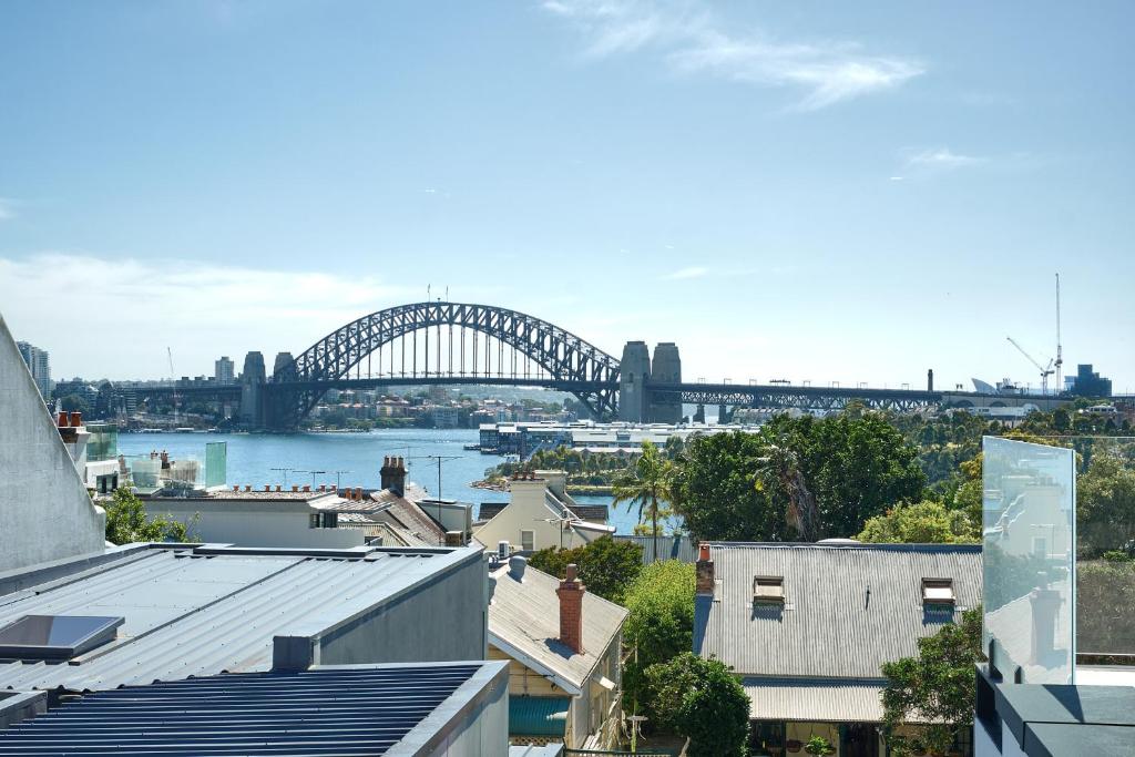 a view of the sydney harbour bridge from the roofs of houses at Retreat on Darling - Harbour Views 3 Bed in Sydney
