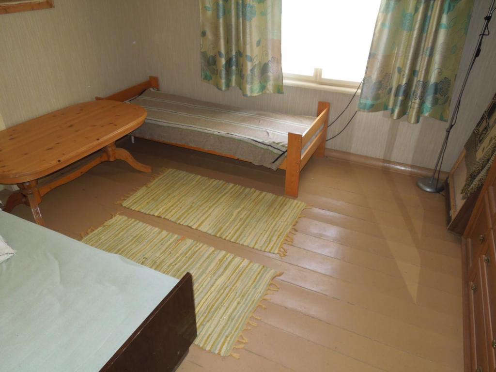 Pokój z łóżkiem, stołem i oknem w obiekcie Holiday Home on Liepajas Street w mieście Aizpute