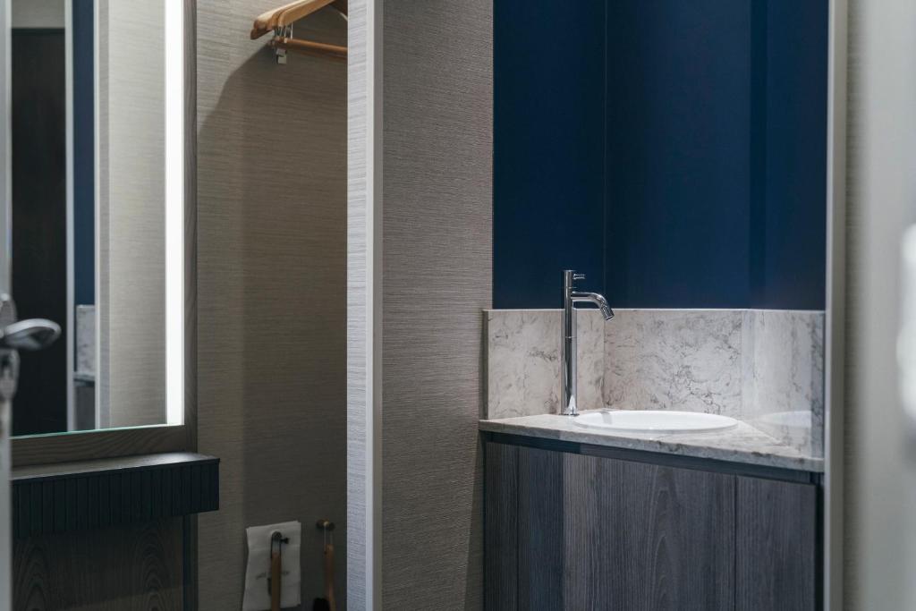 a bathroom with a sink and a blue wall at Hotel JAL City Haneda Tokyo in Tokyo