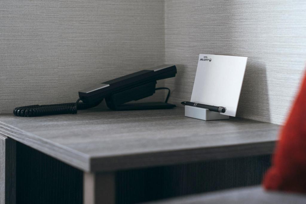 a black phone sitting on top of a table at Hotel JAL City Haneda Tokyo in Tokyo