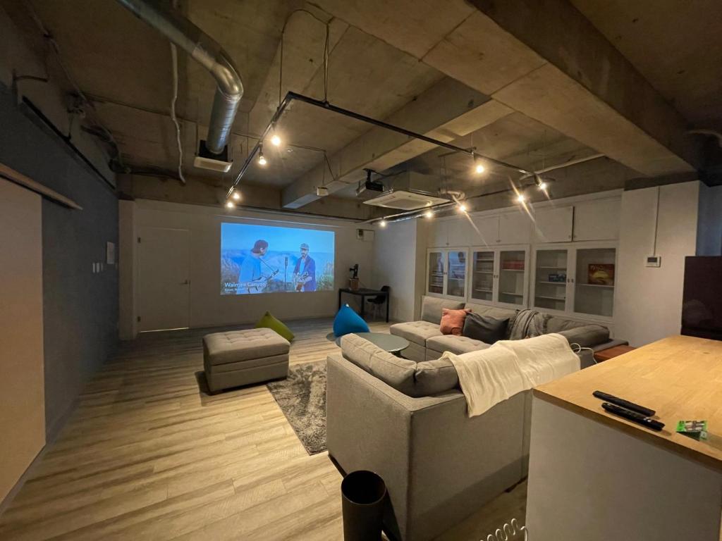 sala de estar con sofá y pantalla de proyección en &HouSE - Vacation STAY 72442v en Takagi
