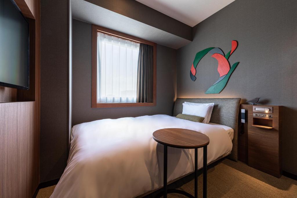 a bedroom with a bed with a table and a window at Hotel JAL City Haneda Tokyo in Tokyo
