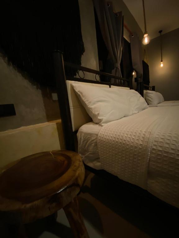 a bedroom with a bed and a stool next to it at Ariché Valladolid Hotel & Hostal in Valladolid