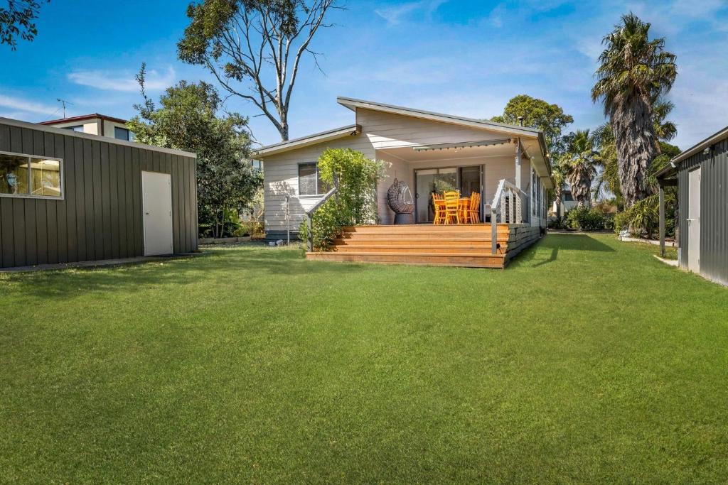 a small house with a deck and a yard at Kilcunda Stay in Kilcunda