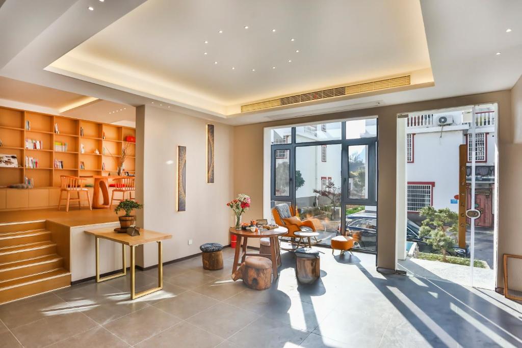 a living room with a table and chairs at Flower Whisperer Homestay Tianmenshan Store free airport and station pick-up in Zhangjiajie