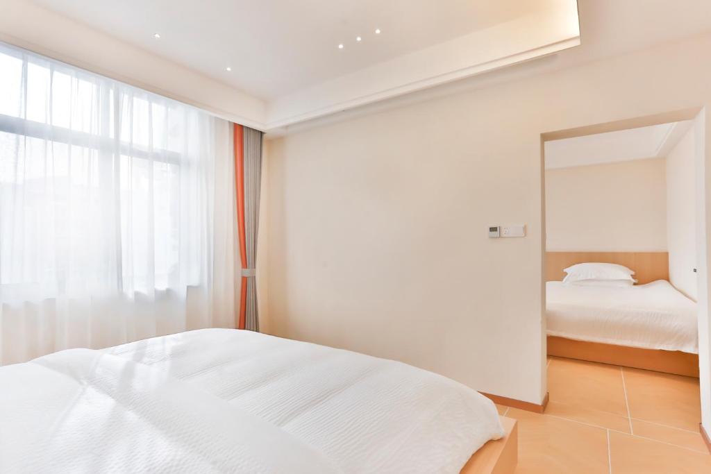 a white bedroom with a mirror and a bed at Flower Whisperer Homestay Tianmenshan Store free airport and station pick-up in Zhangjiajie