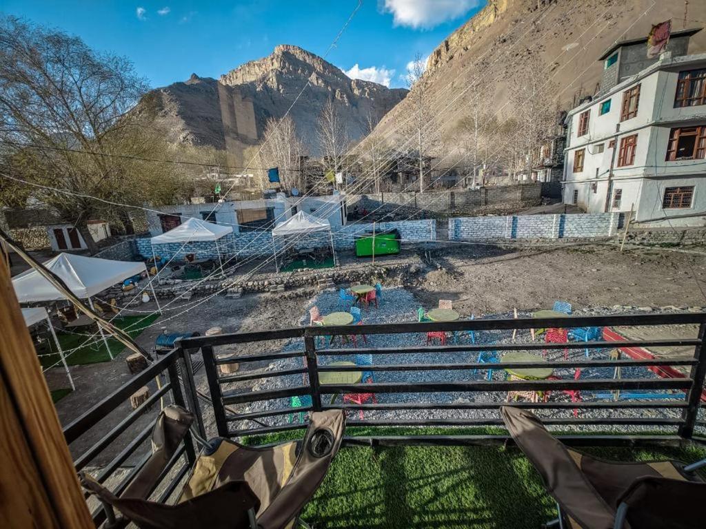 a view of a pool with tents and a mountain at The Alpinist cafe and Retreat in Kaza
