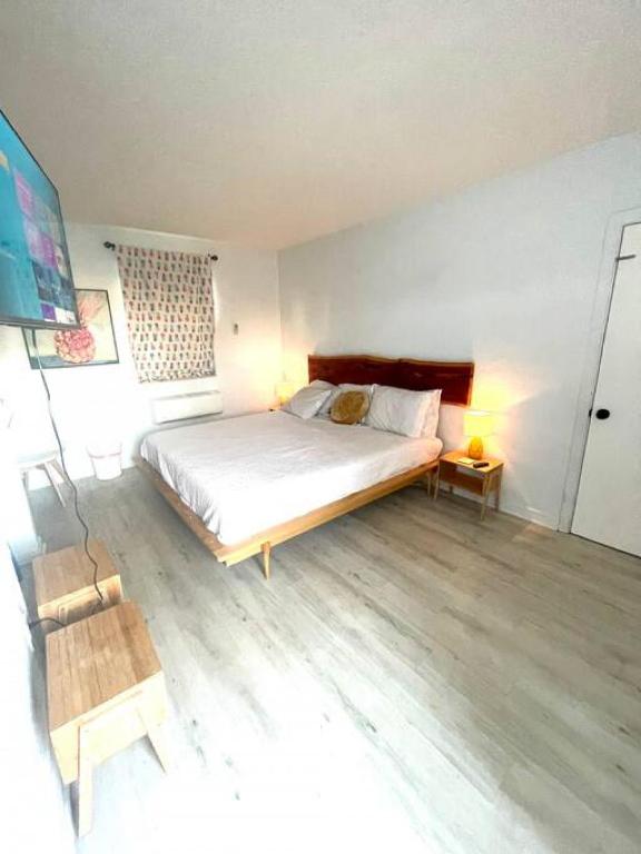 a bedroom with a large bed and a wooden floor at Pineapple Shores Retro Motel 9 in Daytona Beach