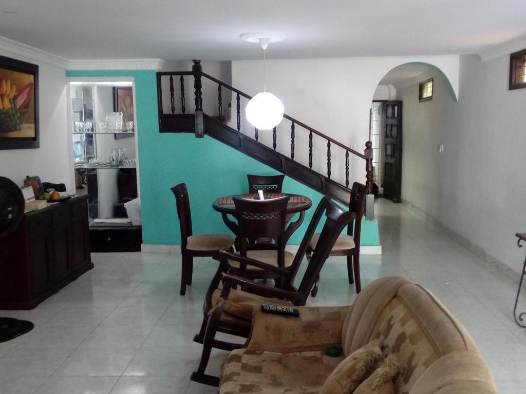 a living room with a table and a staircase at Room in House - Taminaka Hostel in Santa Marta - Private Room in Santa Marta