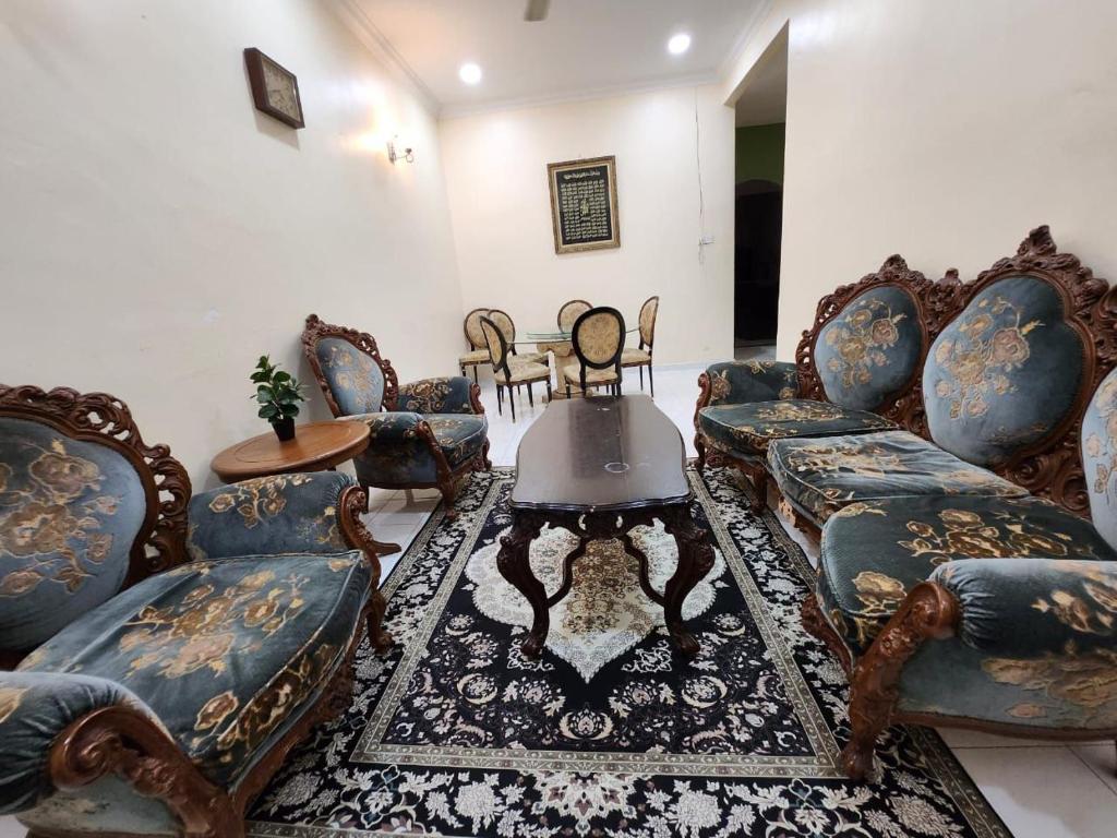 Redzuan Homestay (Muslim Friendly) في موار: غرفة معيشة مع كنب وطاولة قهوة