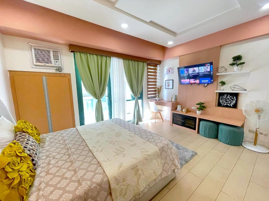 a bedroom with a bed and a tv in it at Two Palm Tree Villas in Manila