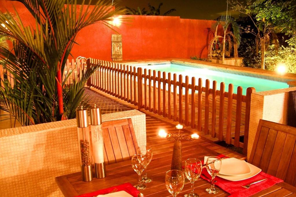 Villa Anakao Abidjan في أبيدجان: طاولة مع كؤوس للنبيذ بجوار حمام سباحة