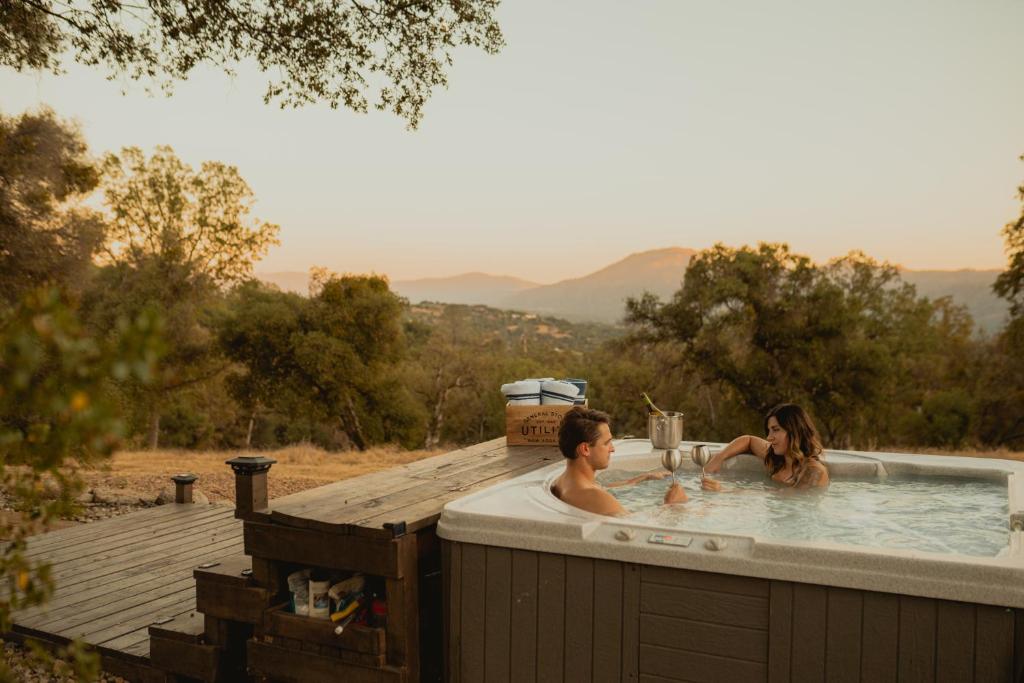 two people in a jacuzzi in a hot tub at Family Farmhouse by Casa Oso with views and spa in Ahwahnee