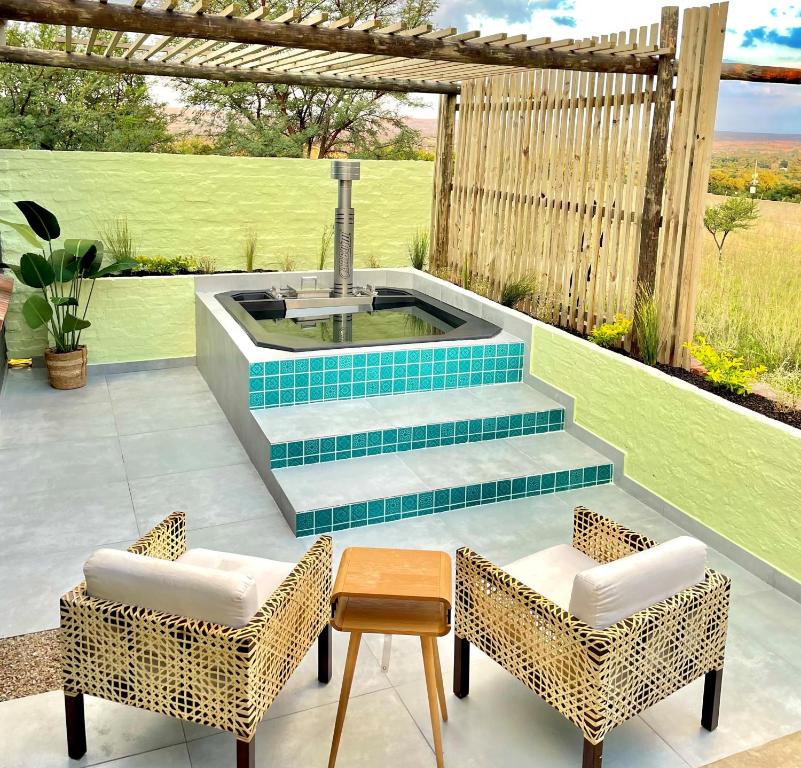 Pretoria的住宿－HAVANA VILLA - Pretoria East Luxury Villa，一个带热水浴缸和两把椅子的庭院