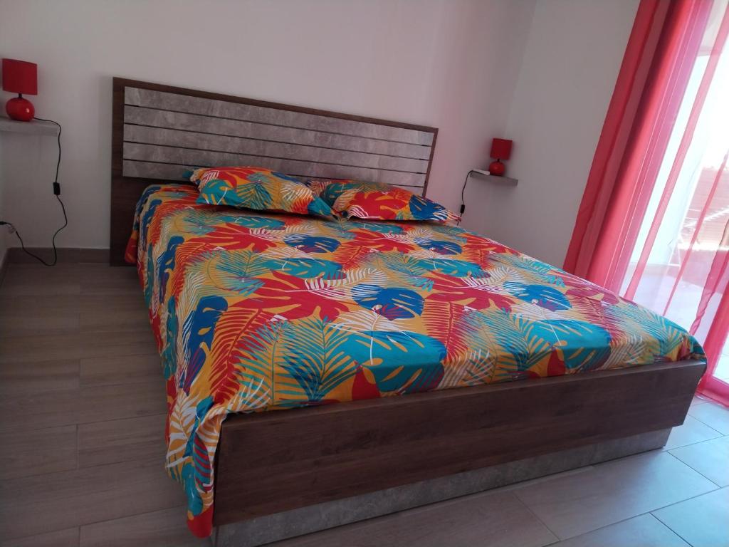 a bedroom with a bed with a colorful comforter at Chez Monblanc in Saint-Joseph