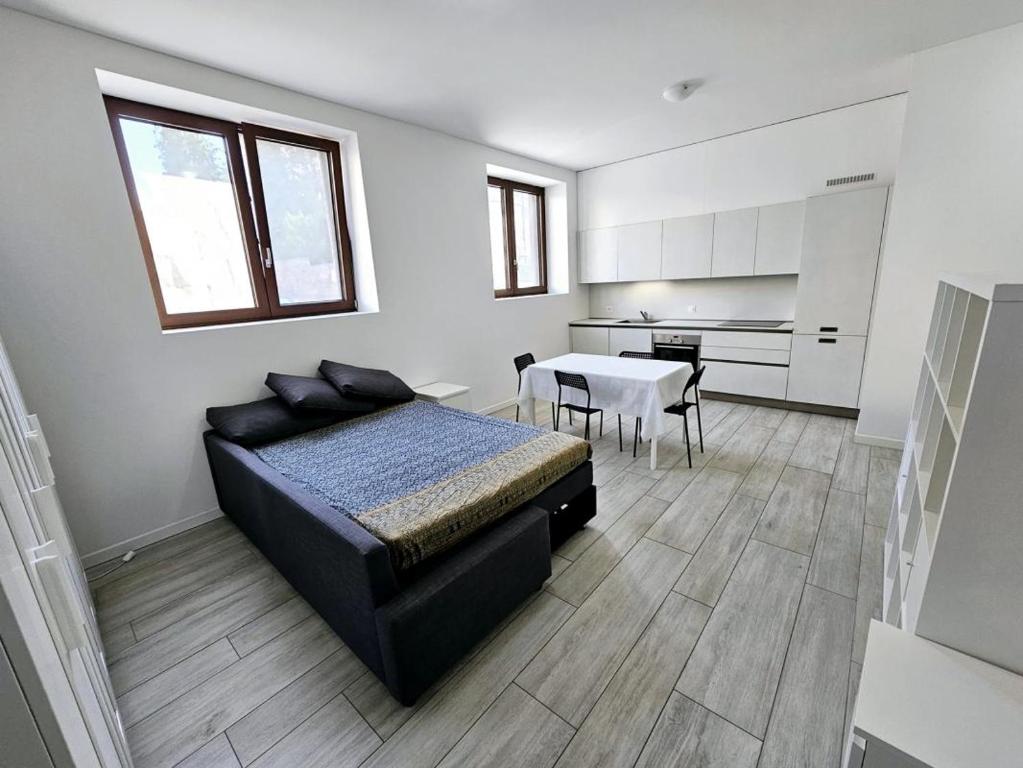 a bedroom with a bed and a table and a kitchen at Monolocale a Mendrisio in Mendrisio