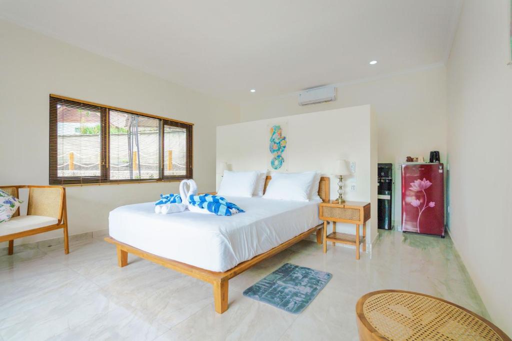 1 dormitorio con 1 cama blanca grande y 1 silla en Lunar Dive Resort: Bamboo Villas en Kubu