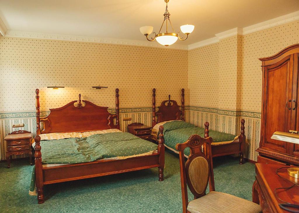 een slaapkamer met 2 bedden en een stoel. bij hotel Memorial in Terezín