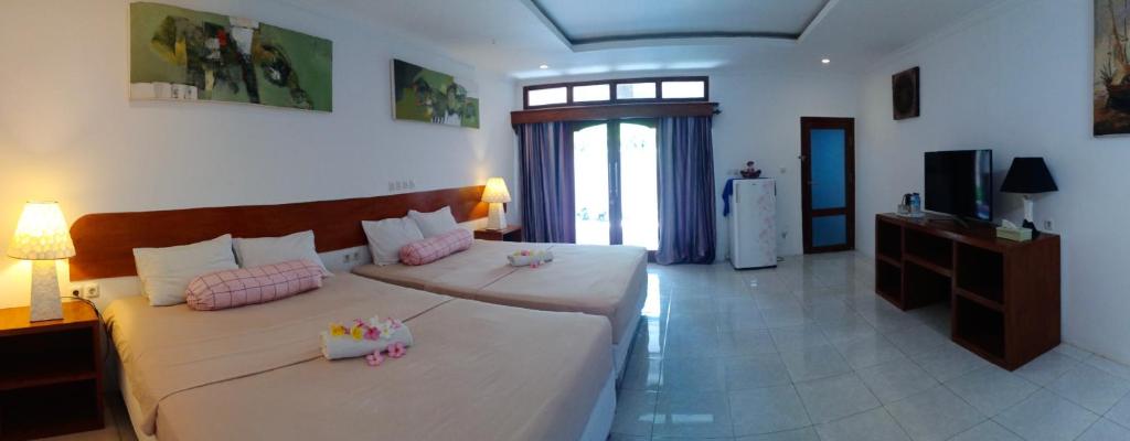 Gili Guest House في غيلي آير: غرفة نوم مع سرير كبير مع وسائد وردية