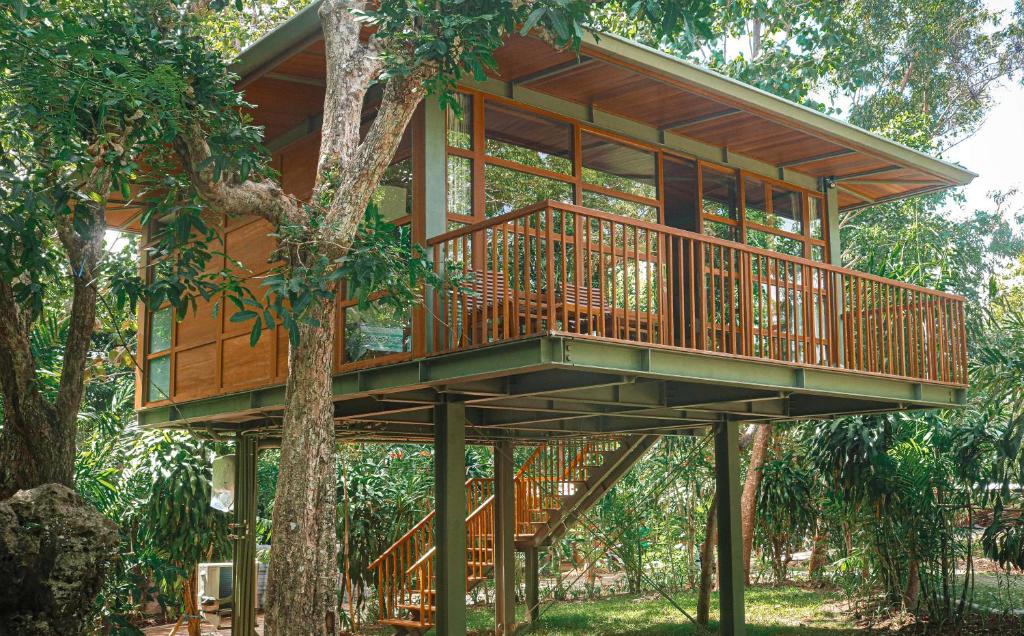 a tree house with a deck in a tree at Grün Resort Uluwatu in Uluwatu