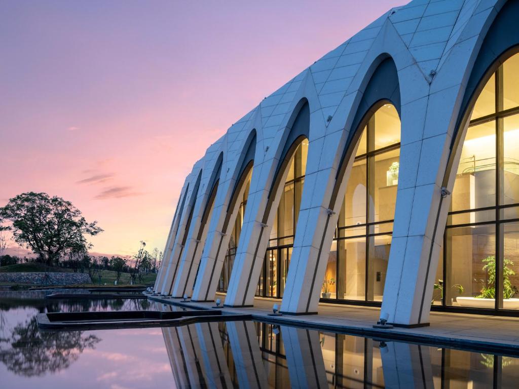 eine Außenansicht eines Gebäudes bei Sonnenuntergang in der Unterkunft S&N Hotel Wucheng in Yongxiu