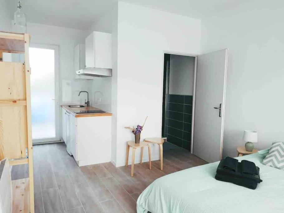 Il comprend une chambre avec un lit et une cuisine avec un évier. dans l'établissement Studio dans impasse proche plages Hossegor, à Bénesse-Maremne