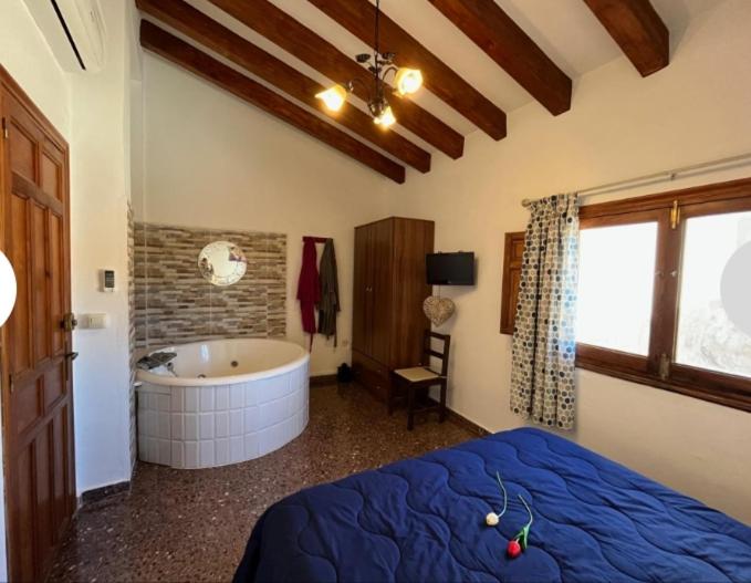 Casa Bella في Bolbaite: غرفة نوم مع سرير وحوض استحمام
