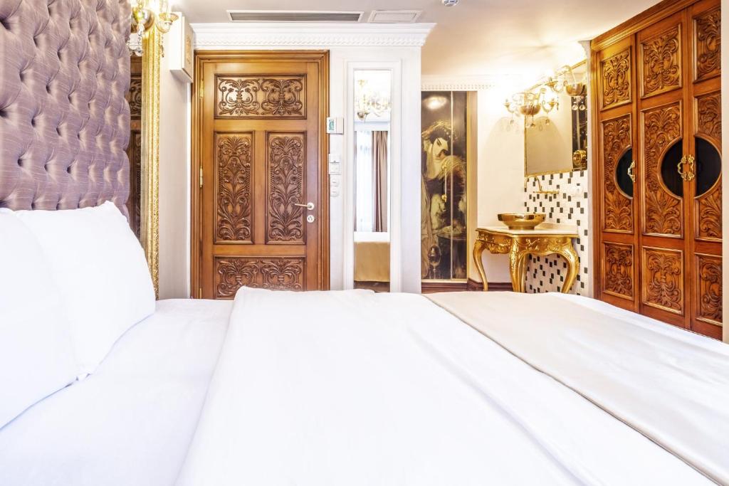 een slaapkamer met een wit bed en een houten deur bij Lovely Studio in Historic Mansion in Beylerbeyi in Istanbul