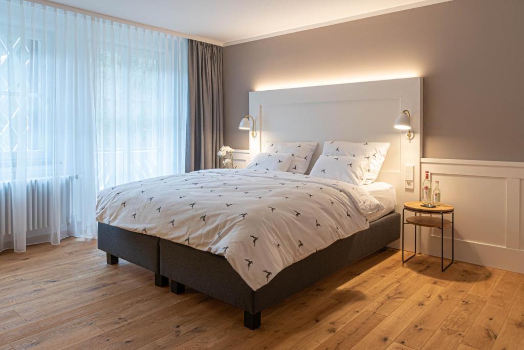 ein Schlafzimmer mit einem großen Bett und einem großen Fenster in der Unterkunft OSCARS Hotel 1415 in Bad Liebenzell