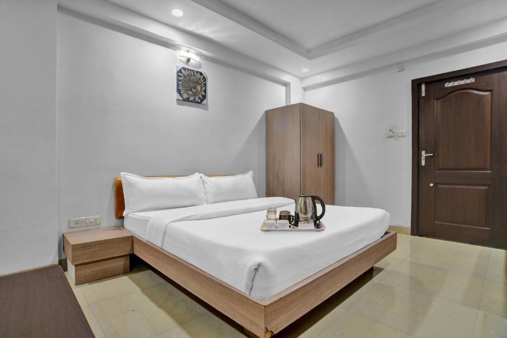 a bedroom with a bed and a wooden cabinet at Townhouse Hotel Divya Palace in Indore