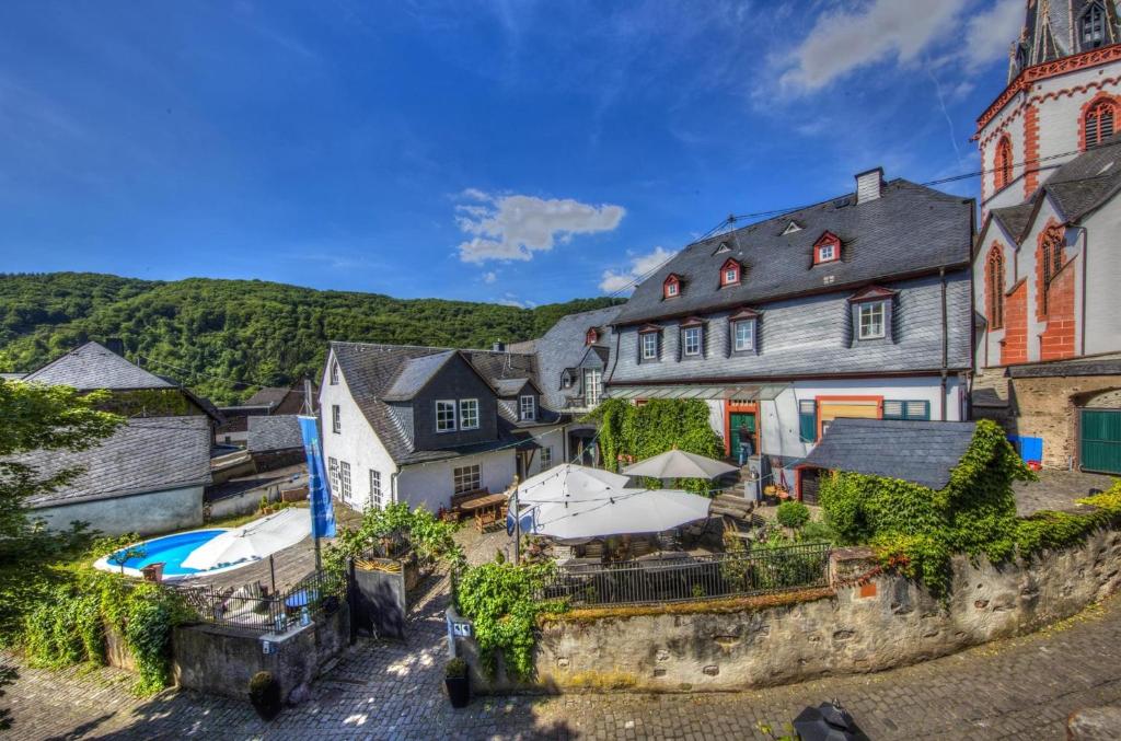 a village with a hotel and a swimming pool at Springiersbacher Hof in Ediger-Eller