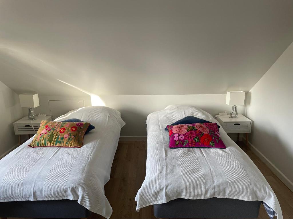 Cette chambre comprend 2 lits avec des draps et des oreillers blancs. dans l'établissement Ledvogterhuset B&B, à Faxe