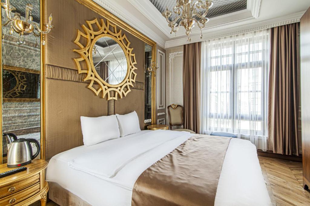 1 dormitorio con 1 cama grande y espejo en Gorgeous Studio in Historic Mansion in Beylerbeyi, en Estambul