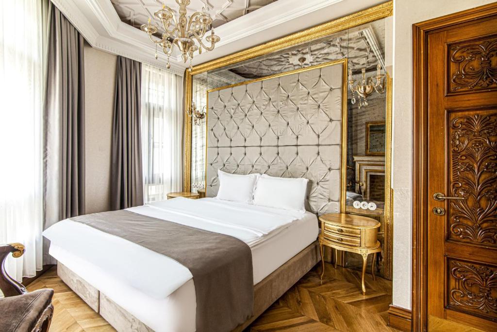 1 dormitorio con 1 cama grande y espejo en Stylish Studio in Historic Mansion in Beylerbeyi, en Estambul