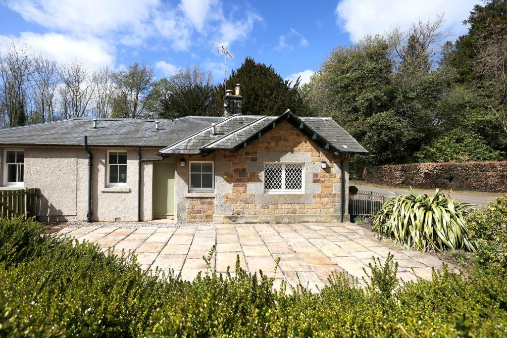 a stone house with a driveway in front of it at The Lodge At Gilmerton House, North Berwick in North Berwick